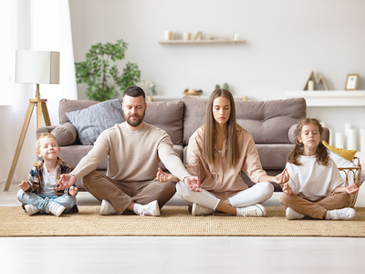 Children practicing belly breathing exercises with their parents